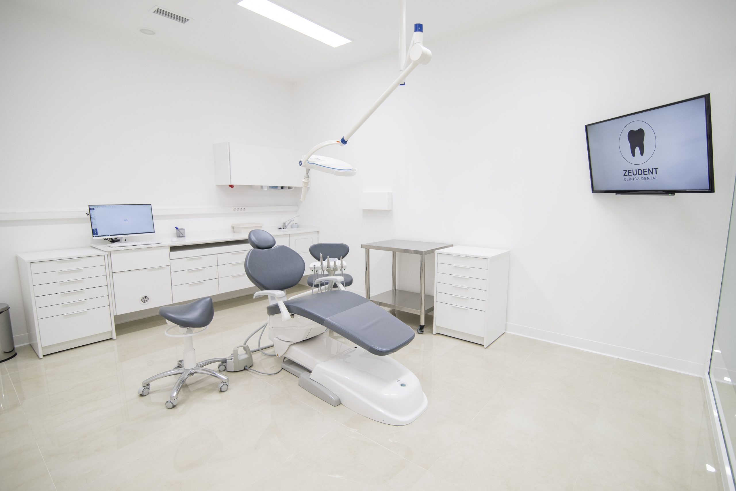 Sala de odontología con muebles y paredes blancas