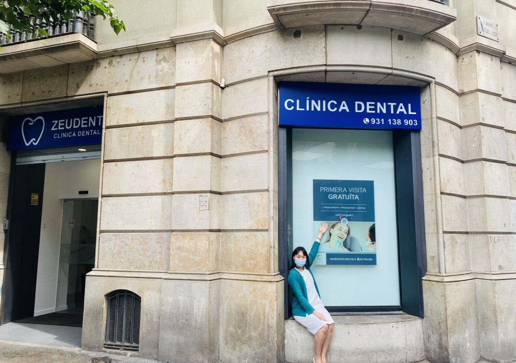 Mujer sentada en ventana de Clínica Dental en barcelona